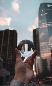 Preview wallpaper crystal ball, ball, hand, reflection, city, buildings