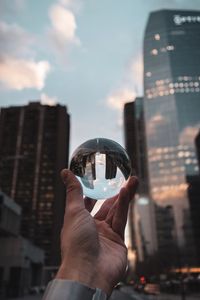 Preview wallpaper crystal ball, ball, hand, reflection, city, buildings