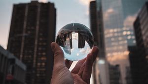 Preview wallpaper crystal ball, ball, hand, reflection, city, buildings