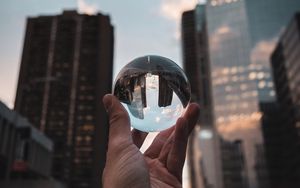 Preview wallpaper crystal ball, ball, hand, reflection, city, buildings