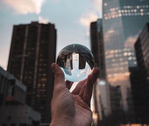 Preview wallpaper crystal ball, ball, hand, reflection, city, buildings