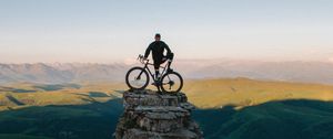 Preview wallpaper cyclist, bicycle, rock, peak, height