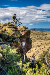 Preview wallpaper cyclist, bike, rock, cliff, nature