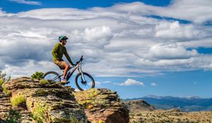 Preview wallpaper cyclist, bike, rock, cliff, nature