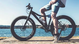 Preview wallpaper cyclist, legs, bicycle, river