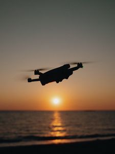 Preview wallpaper drone, silhouette, sea, glare, sky, sunset