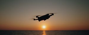 Preview wallpaper drone, silhouette, sea, glare, sky, sunset