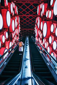 Preview wallpaper escalator, interior, lights, man, steps, red