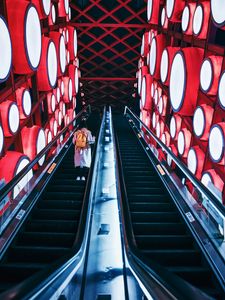 Preview wallpaper escalator, interior, lights, man, steps, red