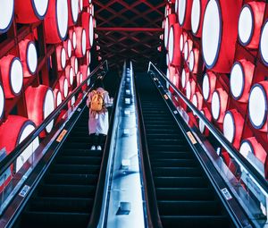 Preview wallpaper escalator, interior, lights, man, steps, red