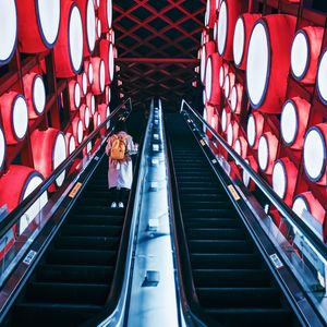 Preview wallpaper escalator, interior, lights, man, steps, red