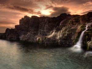 Preview wallpaper falls, twilight, rocks, coast, sky, clouds, emptiness, colors