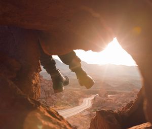 Preview wallpaper feet, cave, rock, mountain, sunset