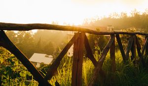 Preview wallpaper fence, grass, houses, trees, rays, sun, nature