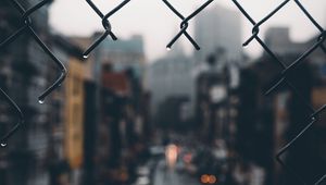 Preview wallpaper fence, grid, hole, rain, city, blur