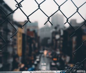 Preview wallpaper fence, grid, hole, rain, city, blur