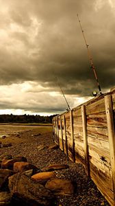 Preview wallpaper fence, stones, sea, coast, fishing tackles