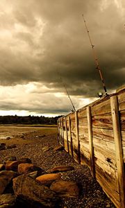 Preview wallpaper fence, stones, sea, coast, fishing tackles