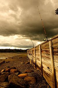 Preview wallpaper fence, stones, sea, coast, fishing tackles