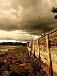 Preview wallpaper fence, stones, sea, coast, fishing tackles