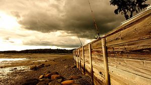 Preview wallpaper fence, stones, sea, coast, fishing tackles