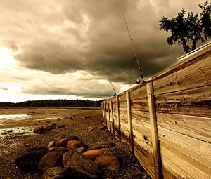 Preview wallpaper fence, stones, sea, coast, fishing tackles