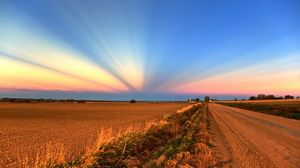 Preview wallpaper field, road, crops, agriculture, evening, decline, beams