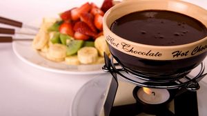 Preview wallpaper fondue, chocolate, candle, fire, fruit, plate, banana, kiwi, strawberry