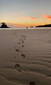 Preview wallpaper footprints, sand, beach, sea, silhouette, sunset