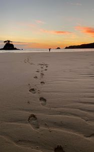 Preview wallpaper footprints, sand, beach, sea, silhouette, sunset