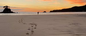 Preview wallpaper footprints, sand, beach, sea, silhouette, sunset