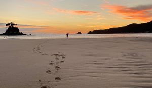 Preview wallpaper footprints, sand, beach, sea, silhouette, sunset