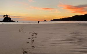 Preview wallpaper footprints, sand, beach, sea, silhouette, sunset