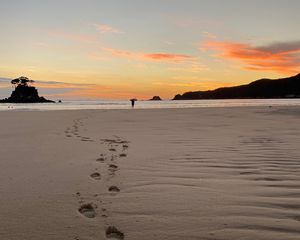 Preview wallpaper footprints, sand, beach, sea, silhouette, sunset