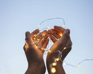 Preview wallpaper garland, glow, hands, sky