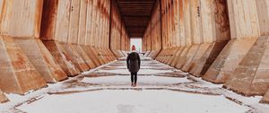 Preview wallpaper girl, alone, building, tunnel, columns, snow, winter