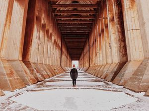 Preview wallpaper girl, alone, building, tunnel, columns, snow, winter