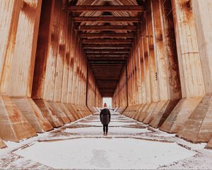 Preview wallpaper girl, alone, building, tunnel, columns, snow, winter