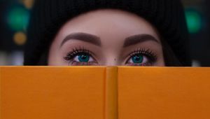 Preview wallpaper girl, book, glance, eyes, face