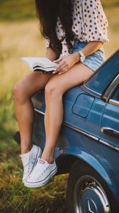 Preview wallpaper girl, book, sneakers, reading, car