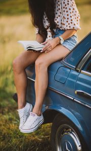 Preview wallpaper girl, book, sneakers, reading, car