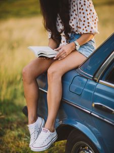 Preview wallpaper girl, book, sneakers, reading, car