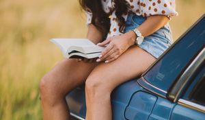 Preview wallpaper girl, book, sneakers, reading, car