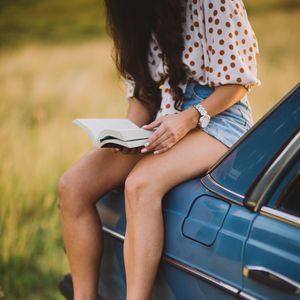 Preview wallpaper girl, book, sneakers, reading, car