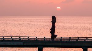 Preview wallpaper girl, bridge, water, dusk, sunset