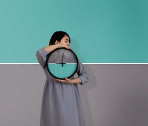 Preview wallpaper girl, clock, wall, symmetry, minimalism