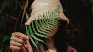 Preview wallpaper girl, fern, leaf, hand, hat, style
