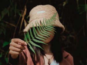Preview wallpaper girl, fern, leaf, hand, hat, style