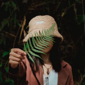 Preview wallpaper girl, fern, leaf, hand, hat, style