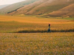 Preview wallpaper girl, field, hills, grass, flowers